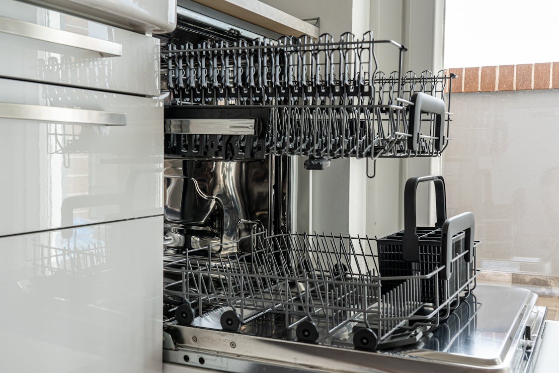 Open dishwasher with clean rack in a modern kitchen