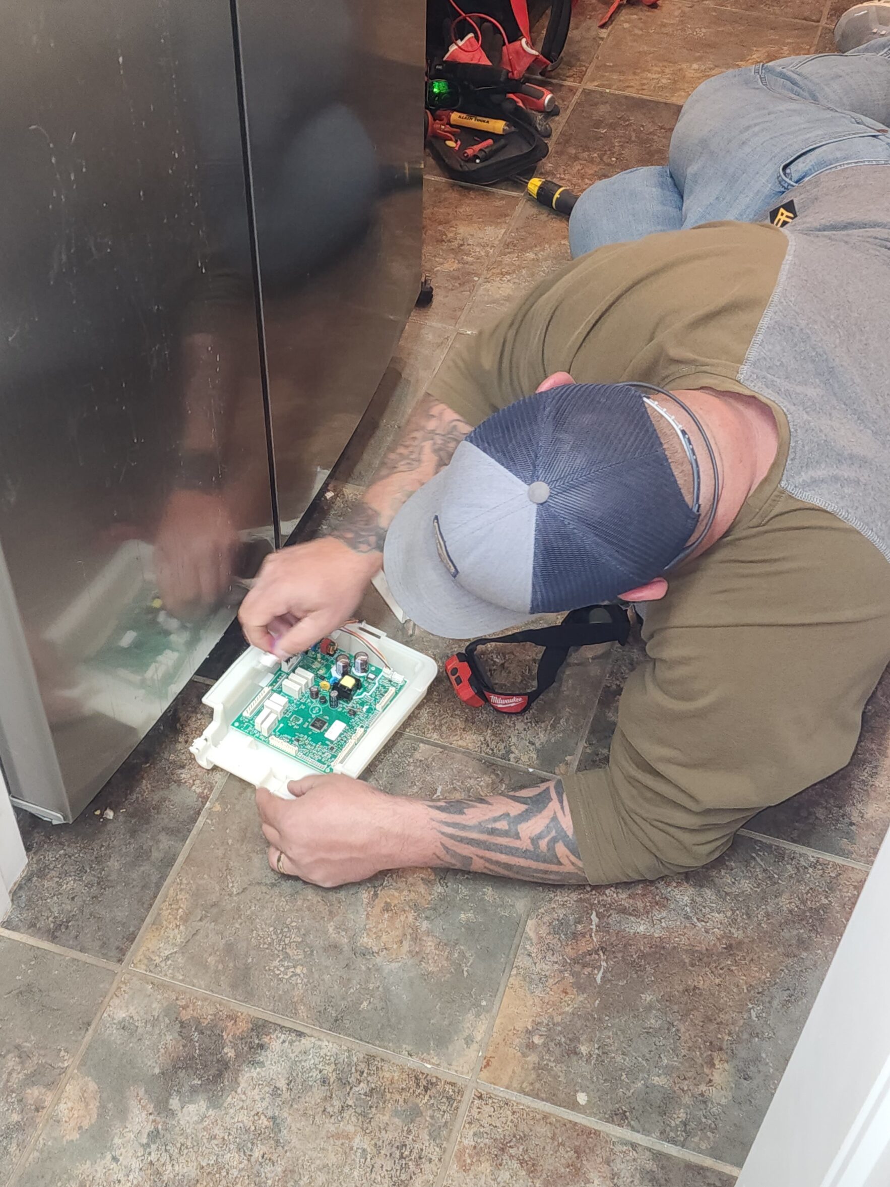 Appliance control board repair - technician diagnosing a Frigidaire refrigerator board in Lubbock TX