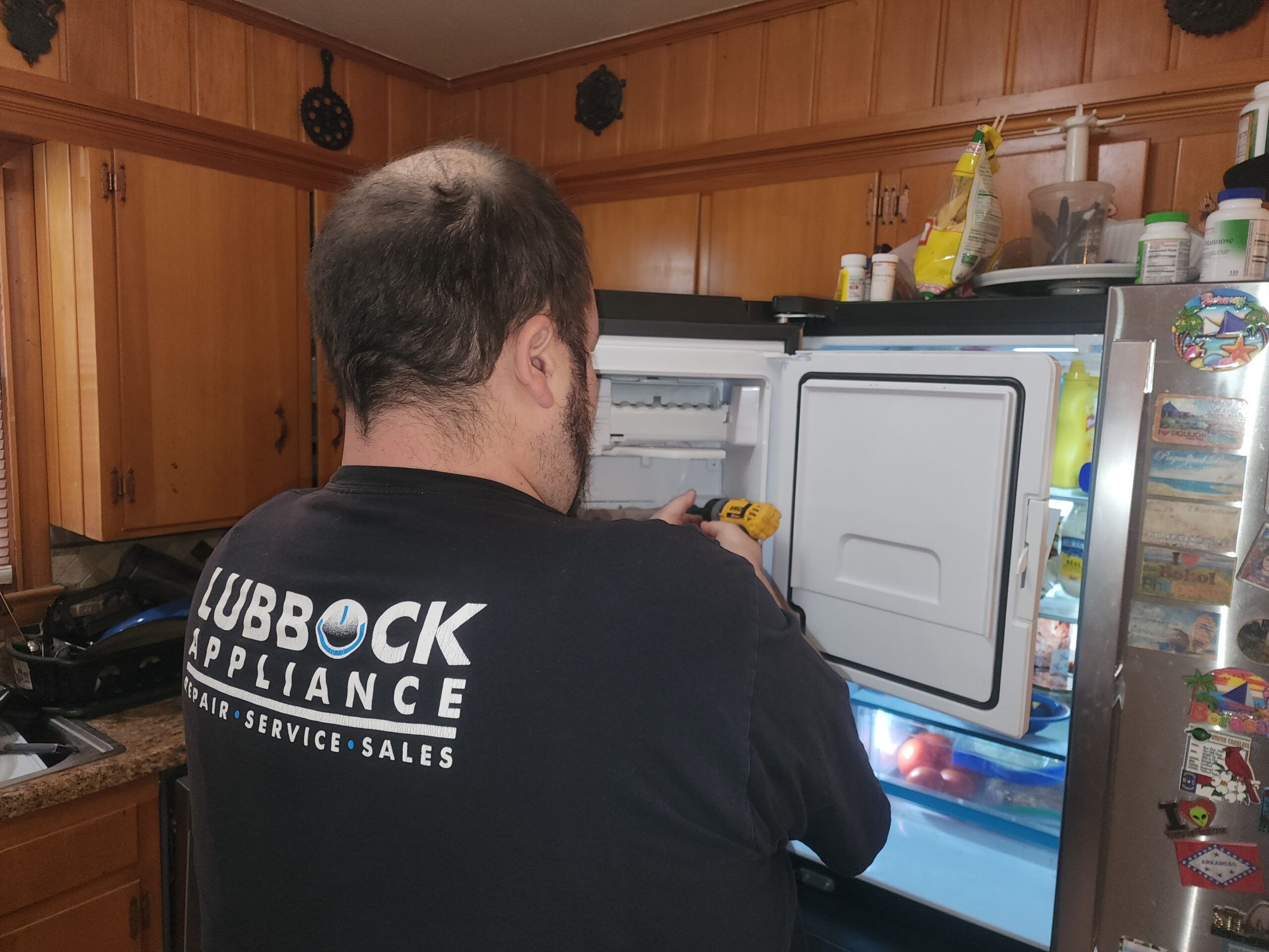 Lubbock Appliance Repair technician repairing a GE refrigerator ice maker