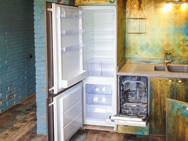 Open refrigerator door showing interior shelves and door frame where model and serial number tag is located